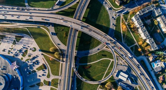 Aerial photograph of a complex highway interchange, capturing dynamic city traffic.
